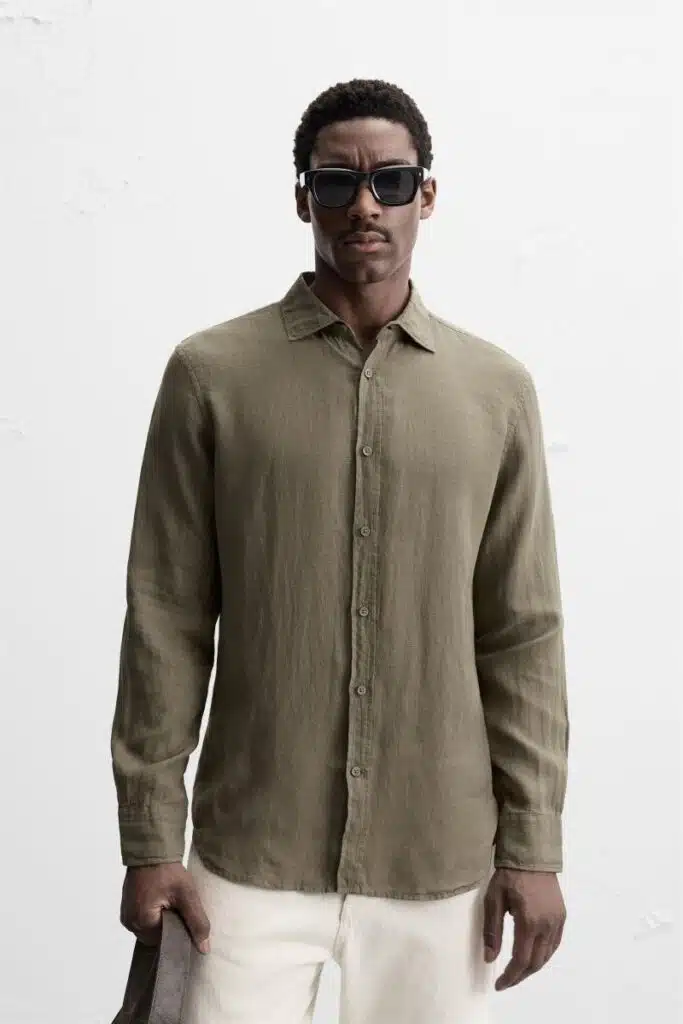Homem com camisa verde-oliva e óculos de sol.