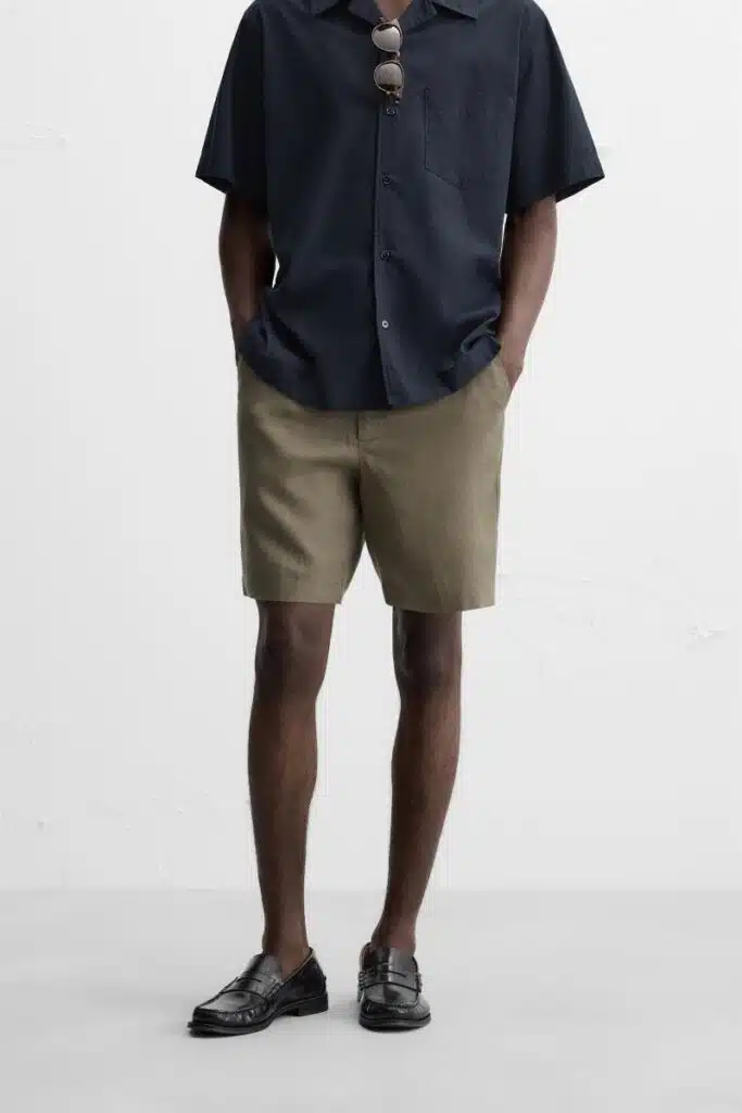 Homem com camisa, calções, sapatos pretos elegantes