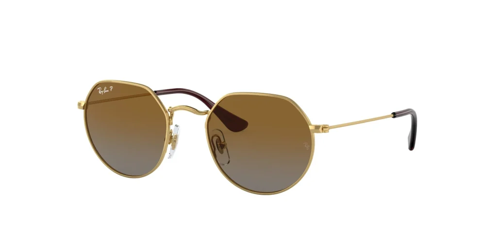 Óculos de sol para crianças da marca Ray Ban com armação metálica dourada de formato geométrico clássico e lentes em tom castanho degradé sobre um fundo branco.