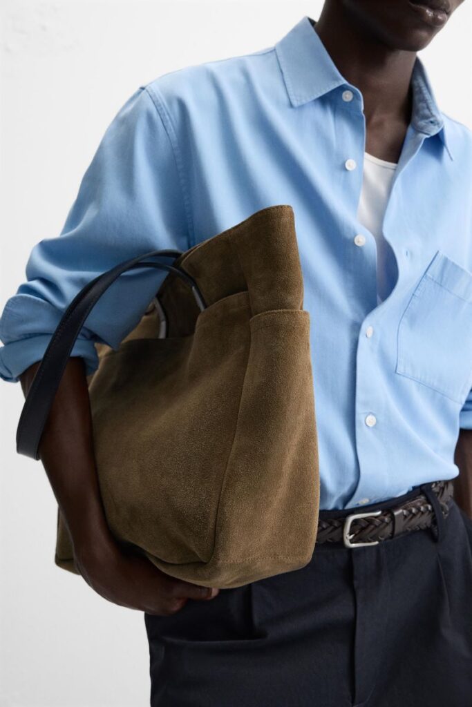 Homem com camisa azul e saco castanho