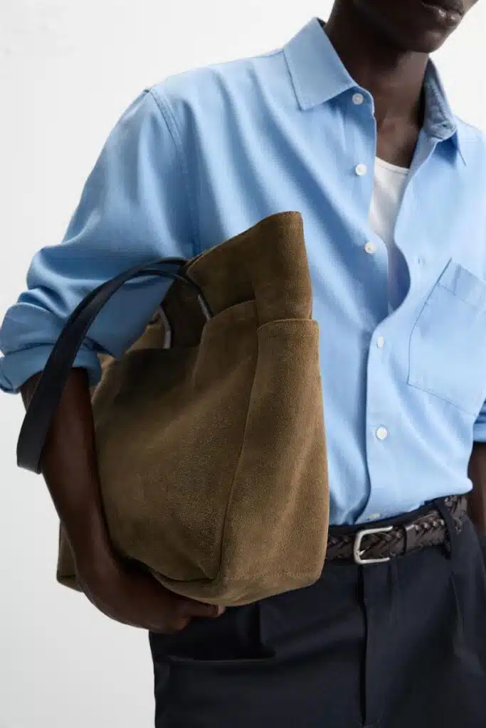 Homem com camisa azul e saco castanho