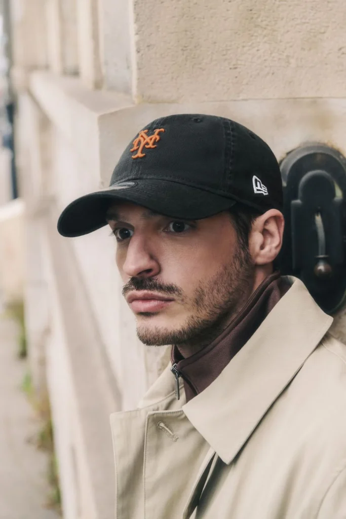 Homem com boné preto SF e gabardine bege.