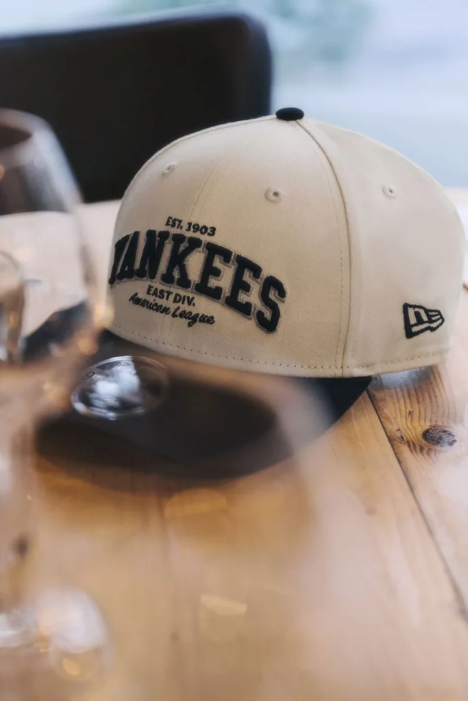 Boné New York Yankees bege New Era em mesa de madeira.