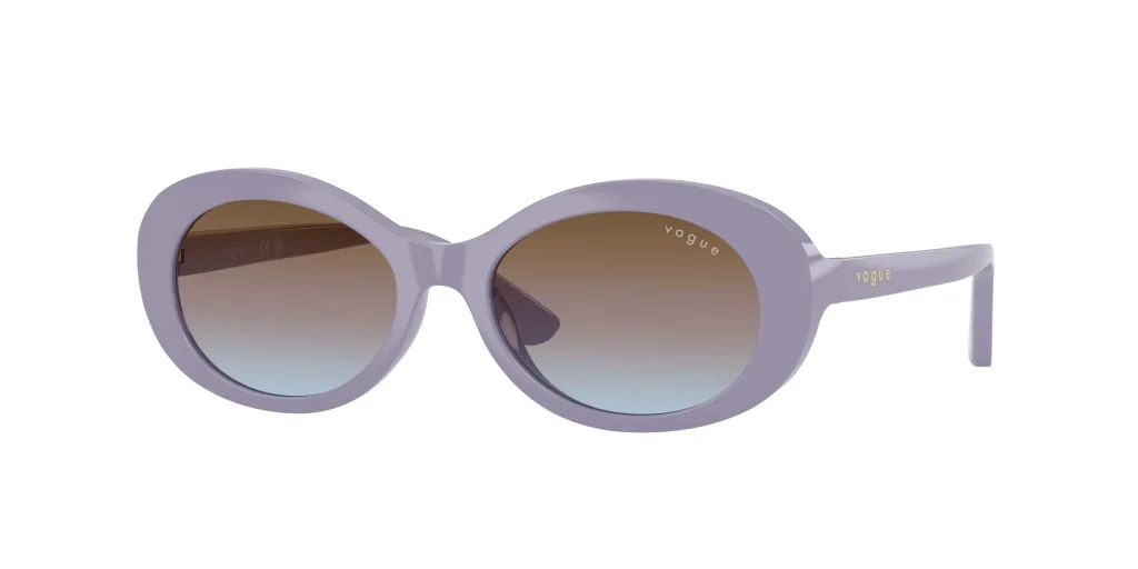 Óculos de sol para crianças desenhados pela Vogue com uma armação oval espessa em tom lilás e lentes de proteção castanhas.