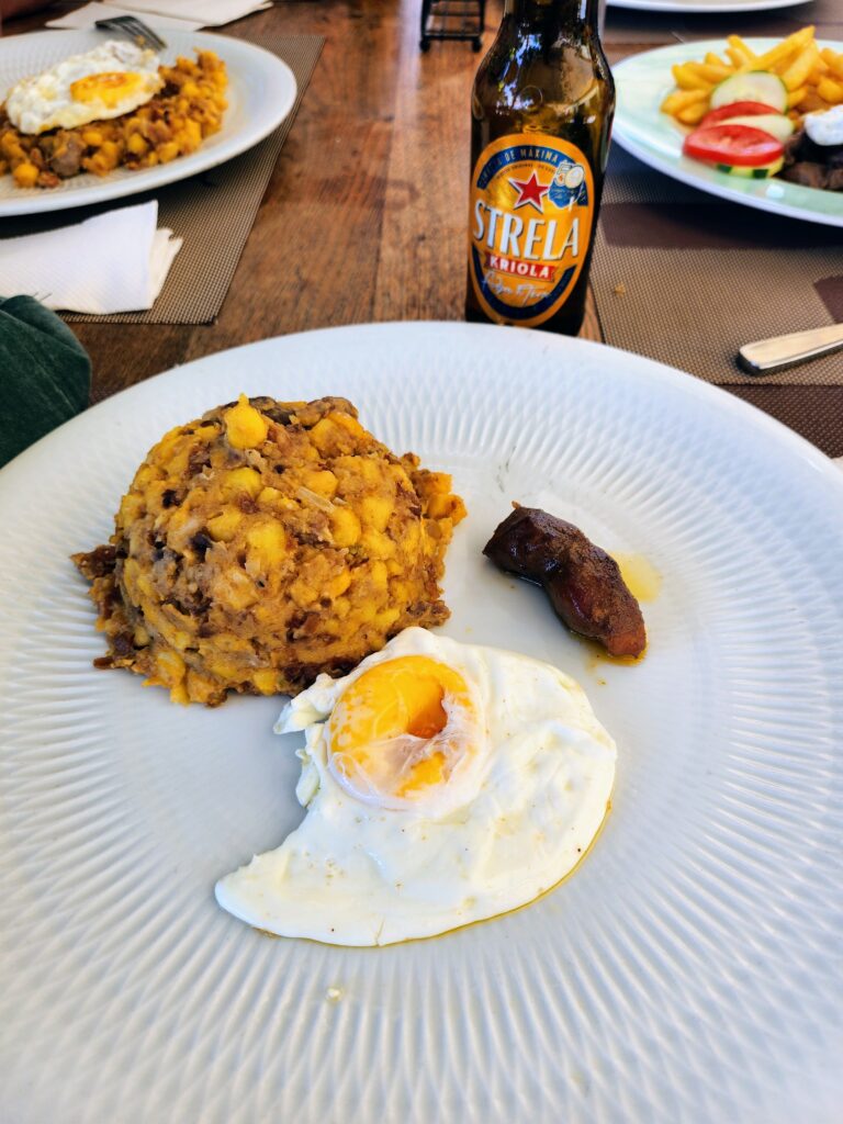 Cachupa tradicional com ovo estrelado e cerveja Strela Kriola.