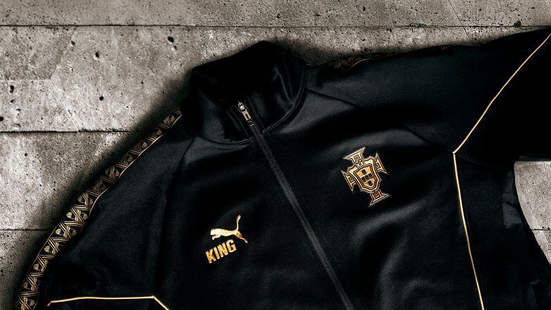 Casaco desportivo preto Puma, detalhe brasão Portugal.