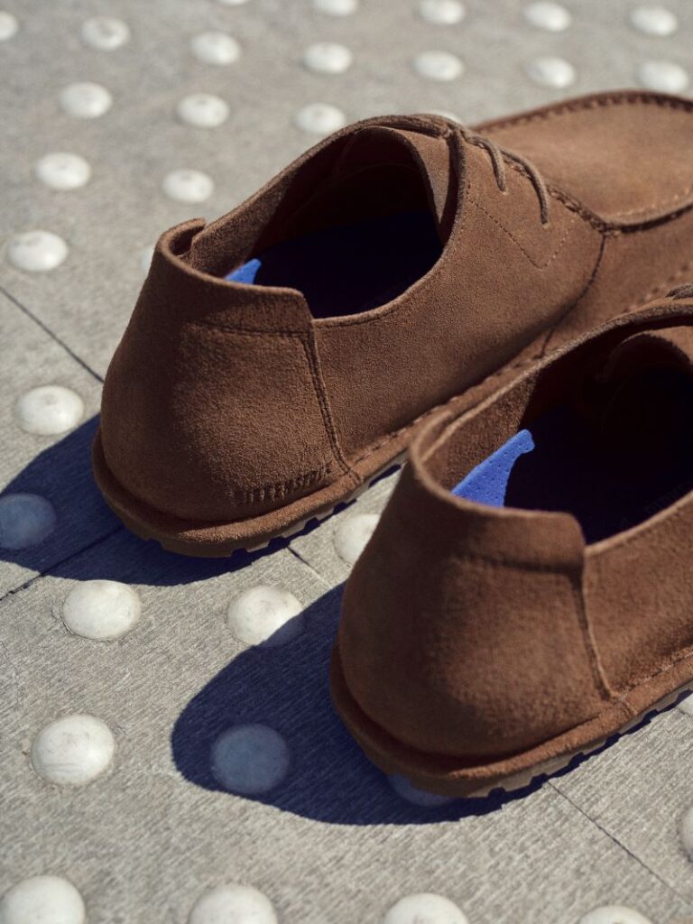 Sapatos castanhos de camurça em chão texturizado.