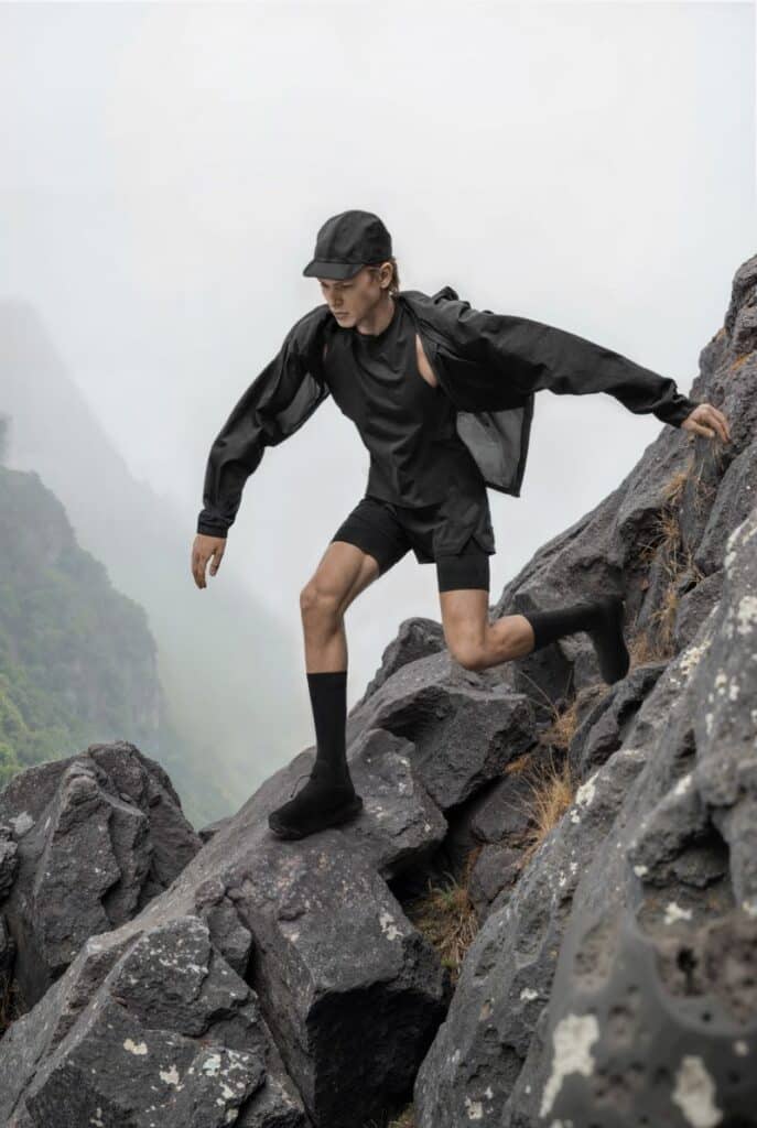 Homem a escalar montanha com roupa desportiva.