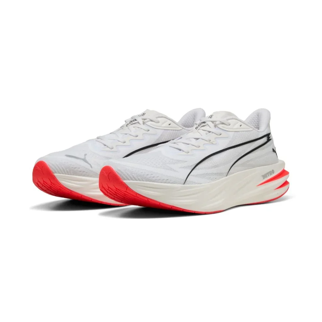 Sapatilhas de corrida Puma brancas com sola laranja vibrante.