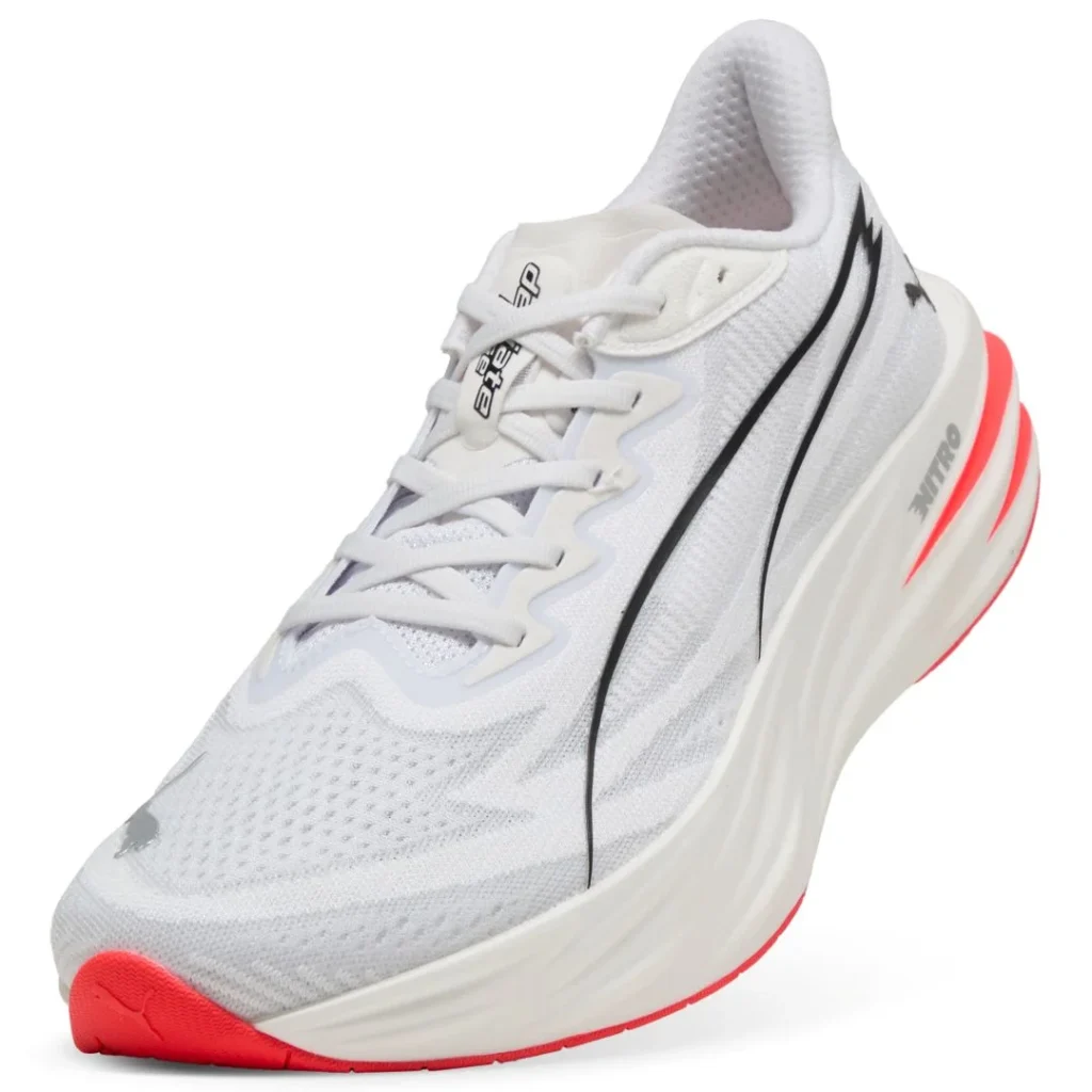 Ténis de corrida Puma brancos com detalhes em vermelho.