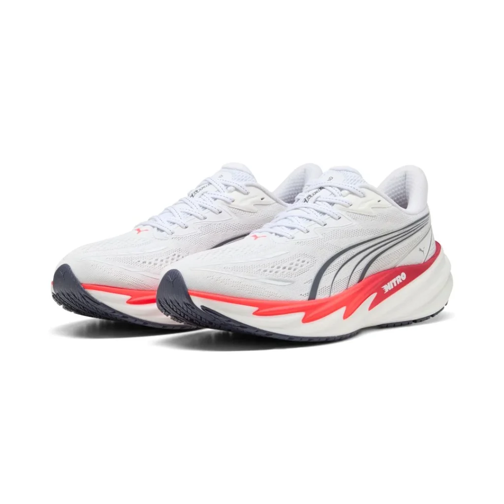 Sapatilhas de corrida Puma brancas e vermelhas em fundo branco.