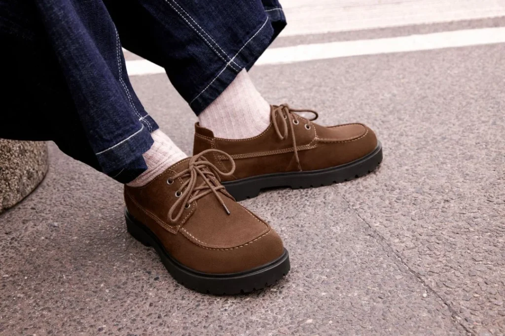 Sapatos castanhos de camurça com atacadores.