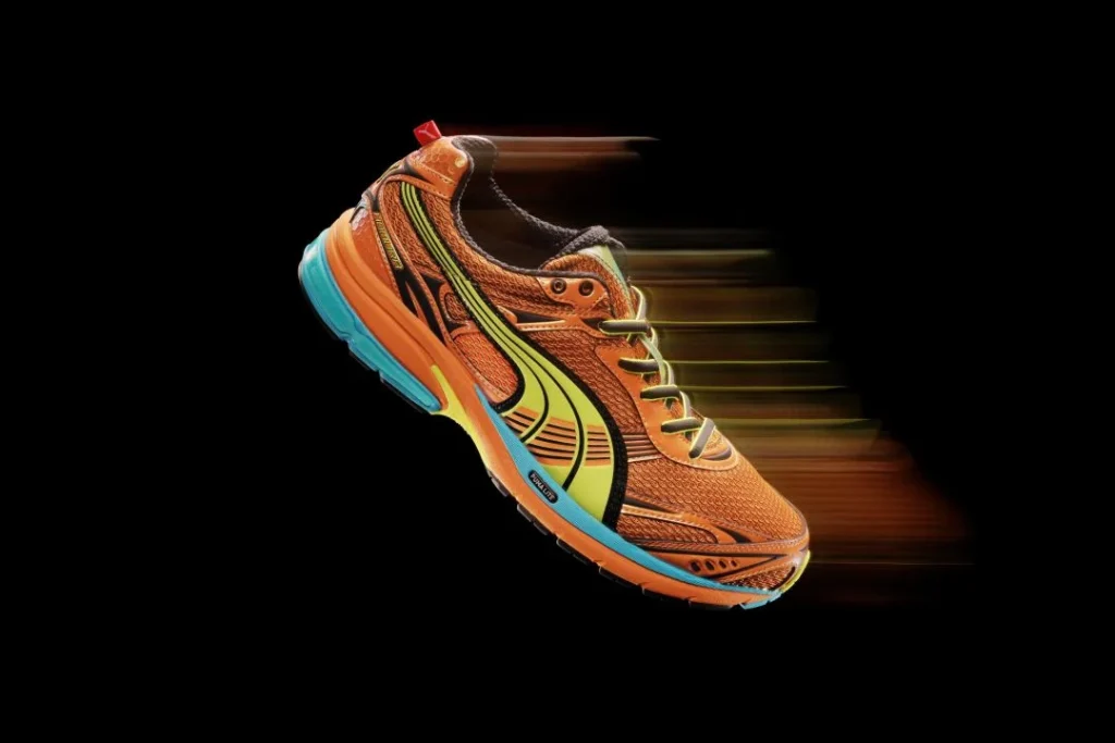 Sapatilha de corrida Puma laranja com efeito de movimento.