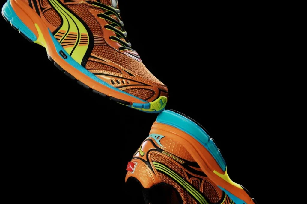 Sapatilhas Puma cor-de-laranja e verde lima em fundo preto.