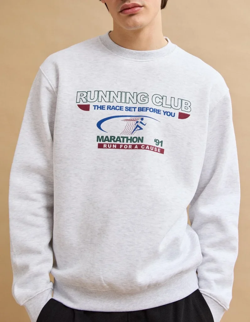 Camisola cinzenta com estampado 'Running Club Marathon' num homem.