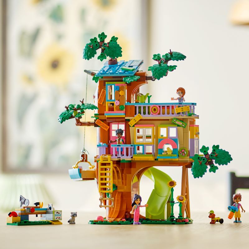 Casa na árvore de brincar com figuras coloridas.