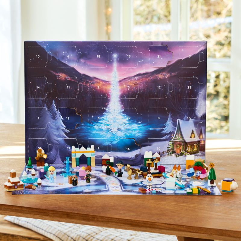 Calendário do advento com mini figuras e cenário natalino.