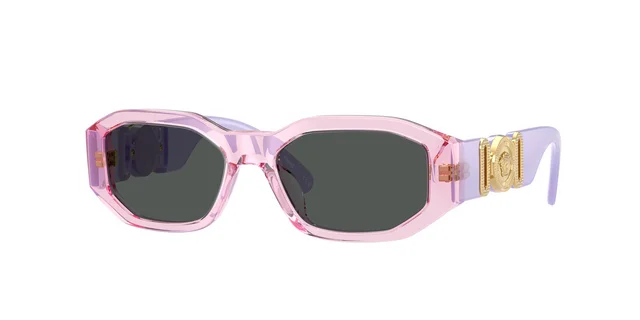 Design geométrico arrojado de óculos de sol para crianças assinado pela Versace com armação grossa e transparente em tom violeta e um logotipo dourado cravado nas hastes.