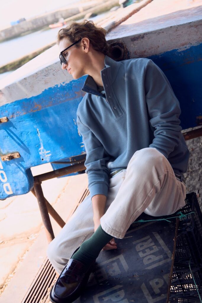 Pessoa sentada ao lado de barco azul.