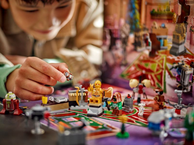 Criança brincando com figuras de construção e robôs.