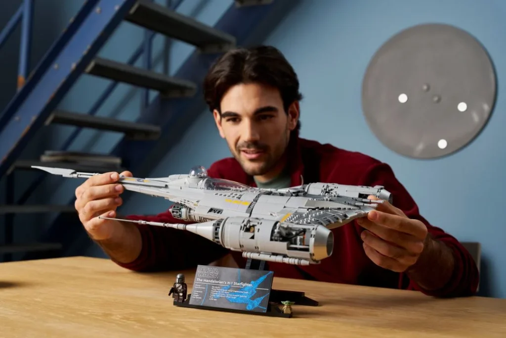 Homem admira modelo LEGO N-1 Starfighter do Mandaloriano.