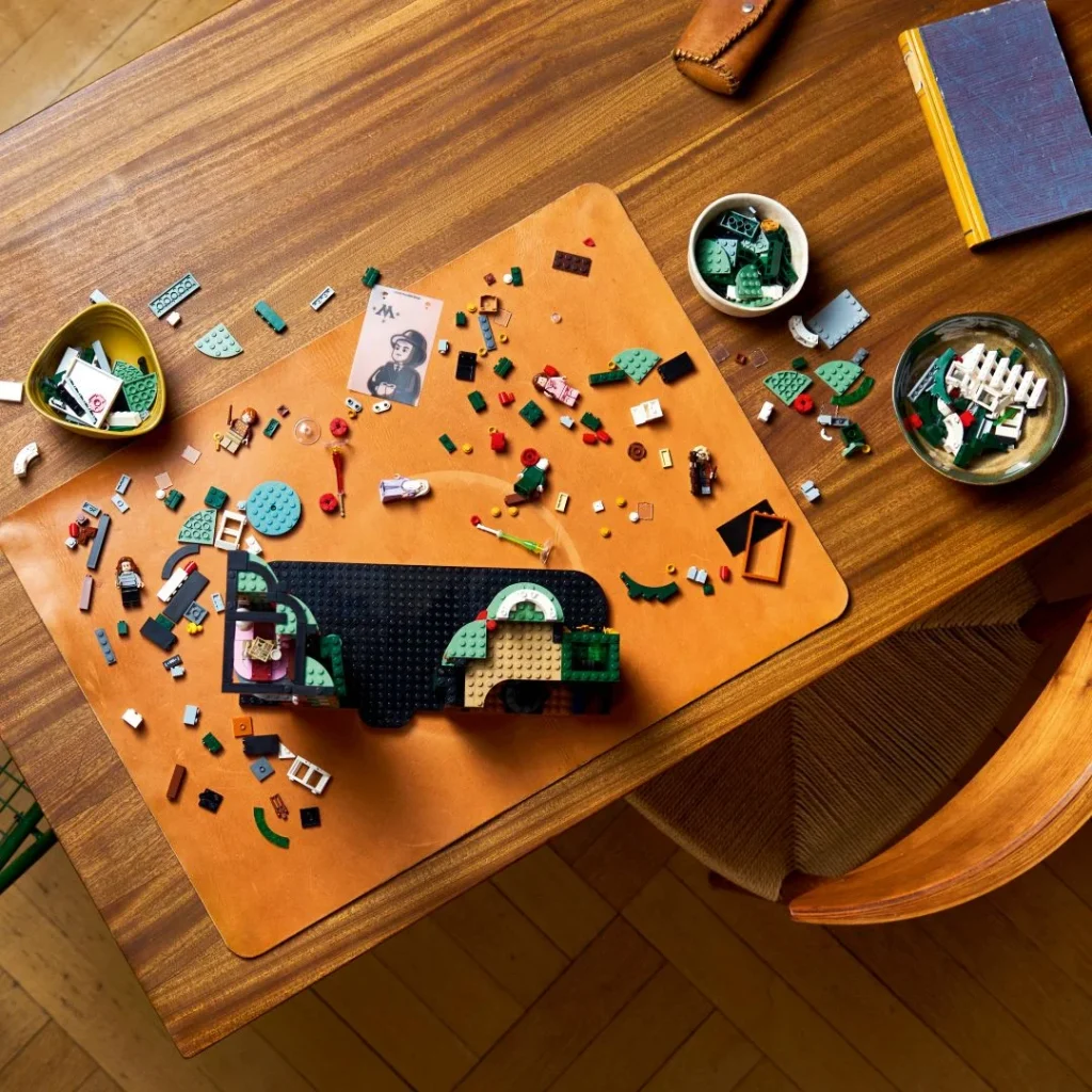 Peças LEGO espalhadas sobre uma mesa rústica vista de cima.