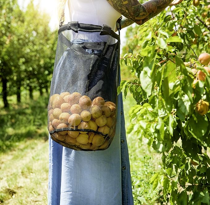 Pessoa colhe frutas com saco de rede.