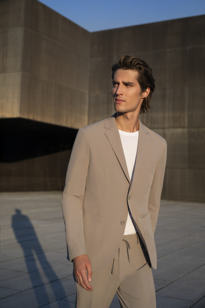 Homem elegante em roupa bege ao ar livre.
