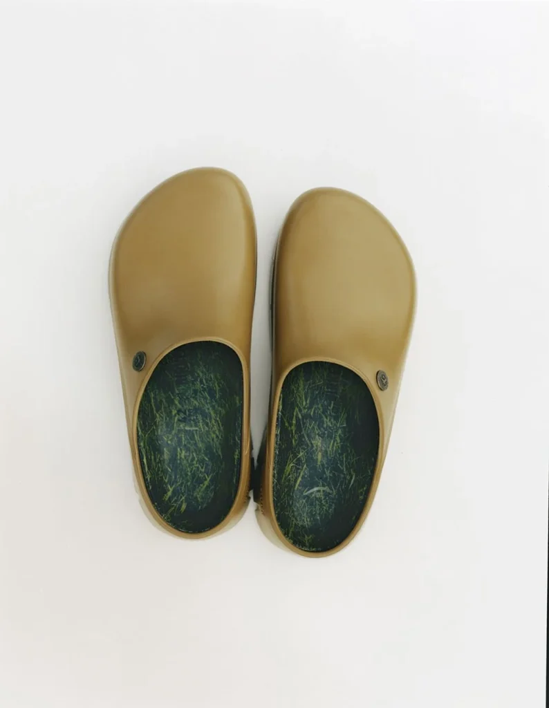 Um par de socas cor-de-azeitona com palmilhas de relva.