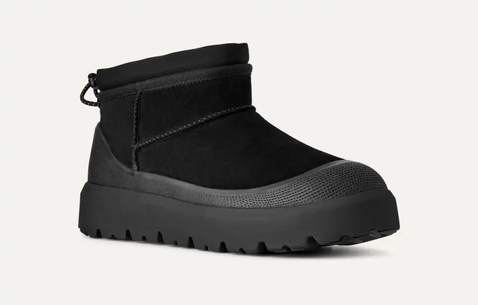 Bota preta de cano curto com biqueira de borracha texturizada e sola grossa, representando as melhores botas de inverno para homem