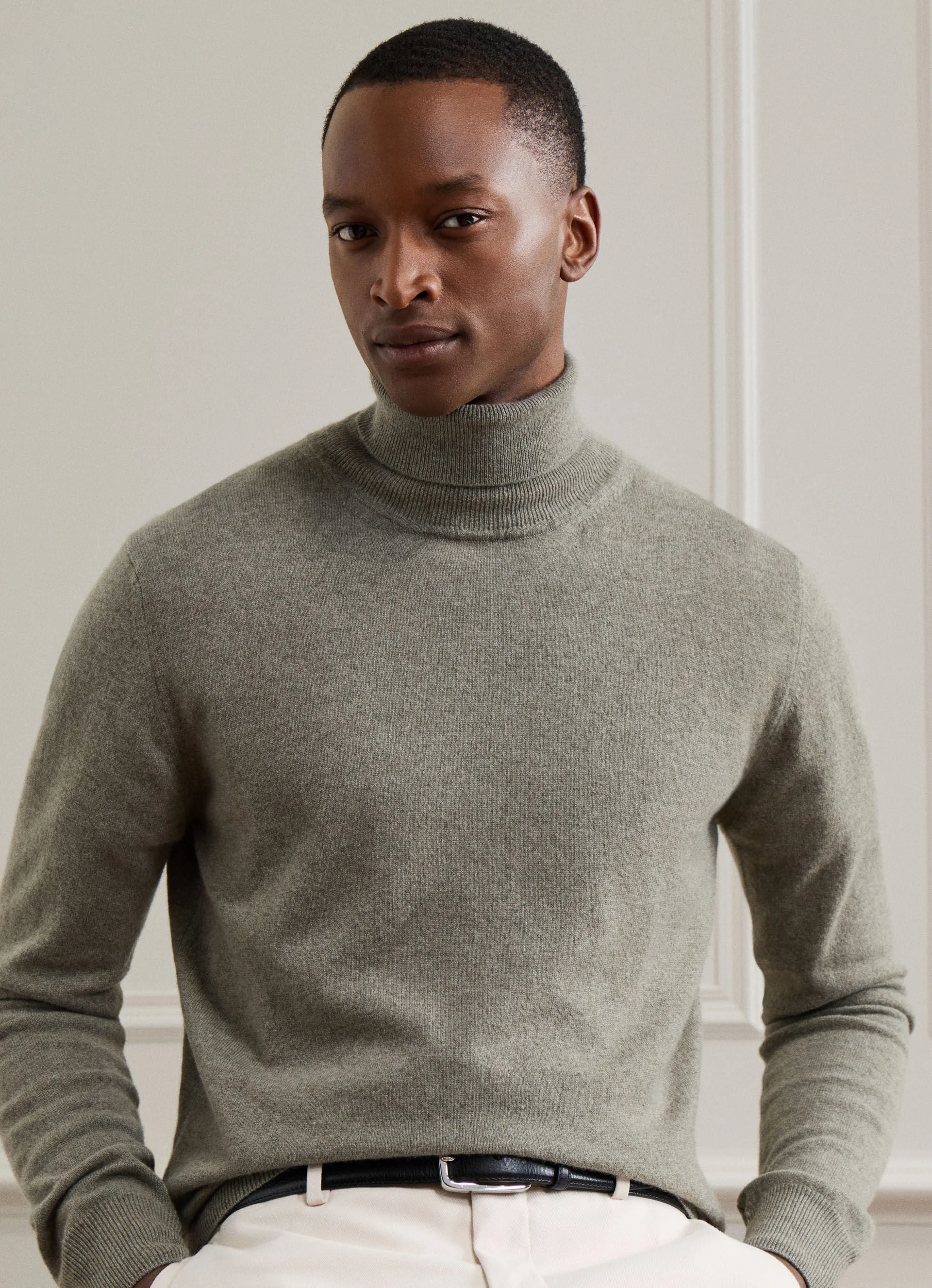 Homem veste camisola de gola alta verde suave e calças claras da coleção outono inverno 2026