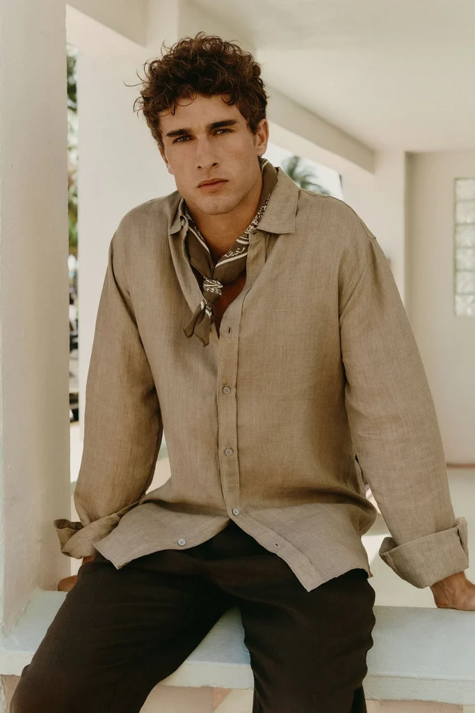 Homem com camisa de linho e lenço ao pescoço.