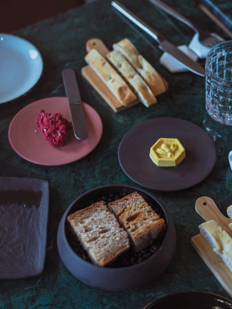 Mesa com pão, manteiga e aperitivos.