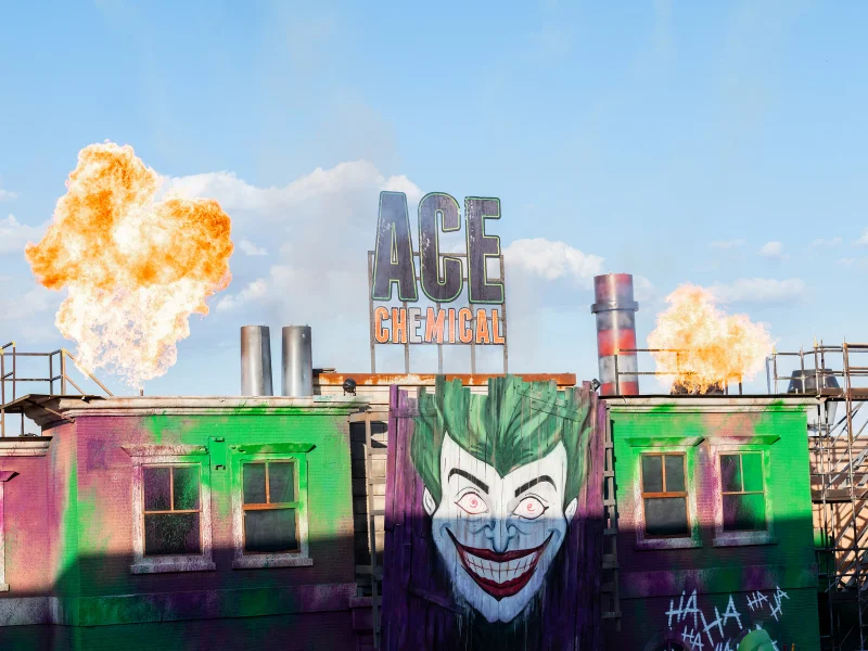 Fachada da Ace Chemical com o rosto do Joker e fogo.
