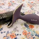 Dispositivo LELO roxo e hidratante pessoal sobre padrão floral.