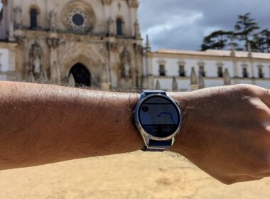 Huawei Watch GT 7 num pulso com o Mosteiro de Alcobaça ao fundo.