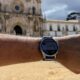 Huawei Watch GT 7 num pulso com o Mosteiro de Alcobaça ao fundo.