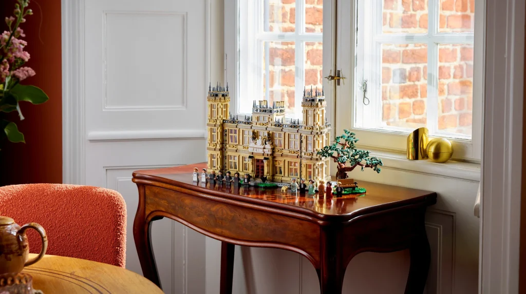 Modelo LEGO de uma mansão senhorial sobre mesa de madeira.