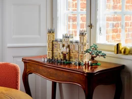 Modelo LEGO de uma mansão senhorial sobre mesa de madeira.