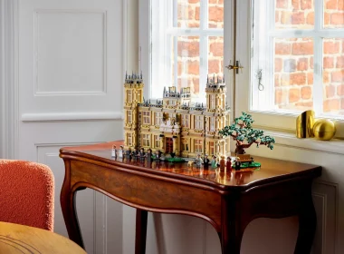 Modelo LEGO de uma mansão senhorial sobre mesa de madeira.