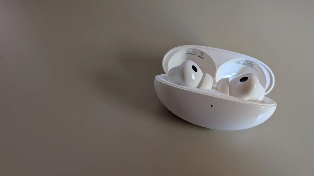 Auriculares sem fios brancos dentro da caixa de carregamento aberta.