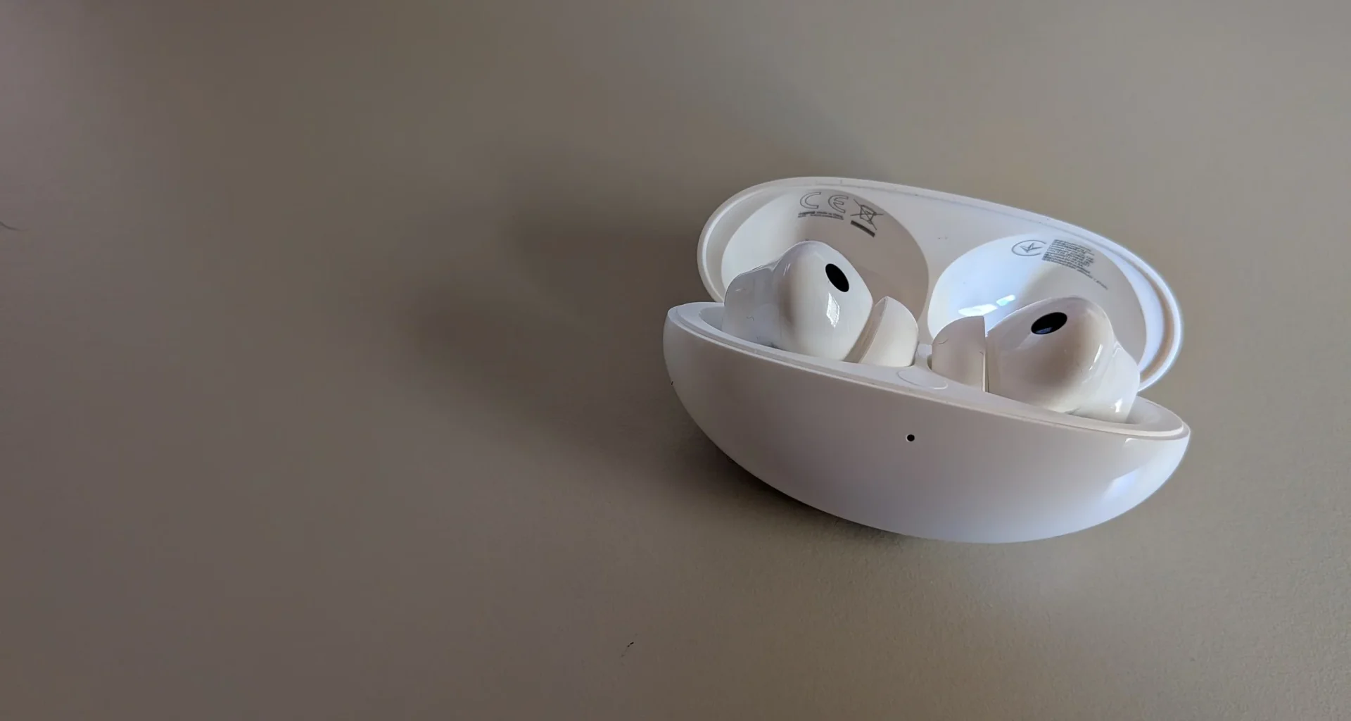 Auriculares sem fios brancos dentro da caixa de carregamento aberta.