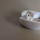 Auriculares sem fios brancos dentro da caixa de carregamento aberta.