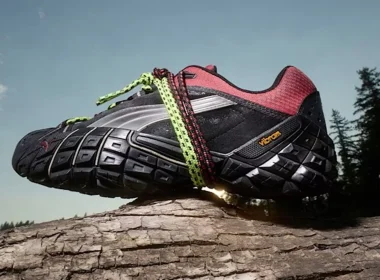 Ténis de trail Puma com sola Vibram sobre um tronco.