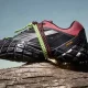 Ténis de trail Puma com sola Vibram sobre um tronco.