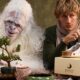 Yeti e homem com sapatos Birkenstock cuidando de um bonsai.