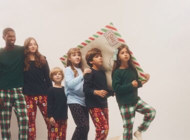 Crianças e adultos em pijamas natalícios juntos.