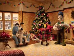 Decoração natalícia com árvore e lareira acesa.