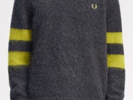 Camisola cinzenta com mangas riscadas amarelas.