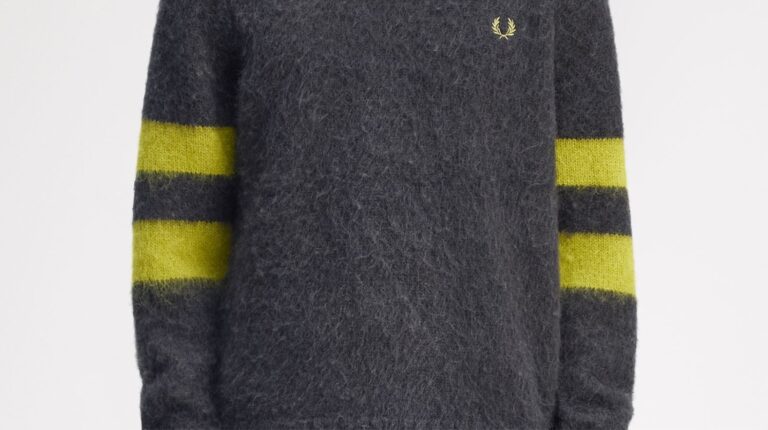 Camisola cinzenta com mangas riscadas amarelas.